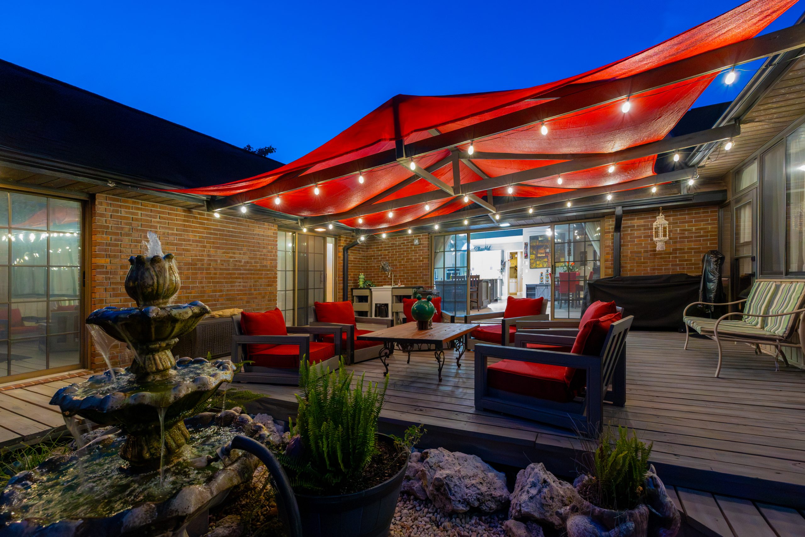 Back deck at twilight, string lights over the seating area
